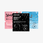 Three packages of Popmask self-heating eye masks. From left to right: pink with text 'Sleep', black with stars pattern and text 'Starry eyes', blue with text 'Jet setter'.